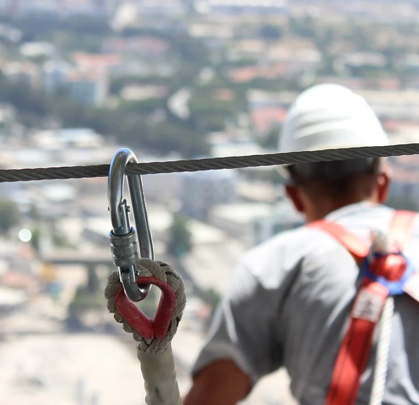 Construction worker clipped in to a harness for safety.